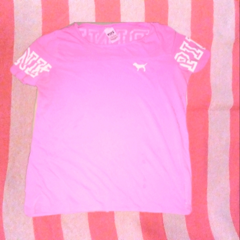 Pink shirt, white lettering across back and on both sleeves size medium